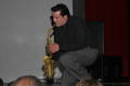 Photograph: [Man playing a saxophone for audience members]