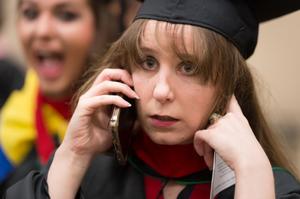 Primary view of object titled '[Graduating Student on her phone at her Commencement Ceremony]'.
