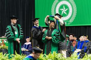 Primary view of object titled '[Ph.D Candidate Being Presented with Doctoral Hood]'.