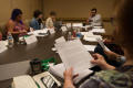 Photograph: [Workshop participants looking at papers]
