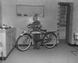 Photograph: [Young Boy Standing Next to a Bicycle]