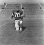 Photograph: [Football player number 70 kneeling in a football field]