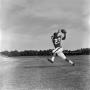 Photograph: [Football player #23 sprinting to catch an incoming pass framed by a …