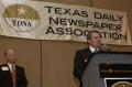 Photograph: [Tony Pederson speaking into a microphone at an TDNA conference]
