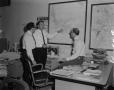 Photograph: [Men in office with market survey map]