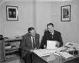 Photograph: [2 men posing at a WBAP office desk]