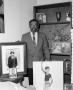 Primary view of [Abner Haynes posing with family portraits]