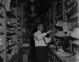 Photograph: [Druggist surrounded by shelves]