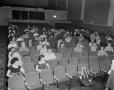 Photograph: [Audience sitting in rows of seats]