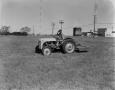 Photograph: [Man on tractor in grass field]