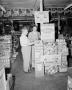 Photograph: [Two men standing next to a Pet Milk display]