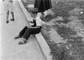 Primary view of [Photograph of a boy sitting on a curb]