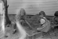 Photograph: [Photograph of two little girls playing in a sandbox]