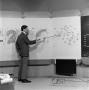 Photograph: [Ken McCool with a weather map]