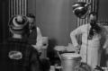 Photograph: [Photograph of men preparing food in a kitchen]