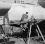 Photograph: [Photograph of two individuals painting a boat]