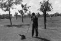 Photograph: [Photograph of Byrd Williams III setting up a tripod outdoors, 2]