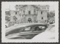 Photograph: [Automobiles driving past the Alamo]