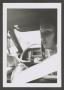 Photograph: [Photograph of a young woman in the passenger seat of the car]