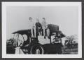 Photograph: [Photograph of three children sitting on top of an automobile]
