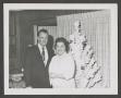 Photograph: [Photograph of a man and a woman posing in front of a Christmas tree]