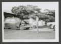 Photograph: [Photograph of two teenage boys standing next to a wrecked automobile]