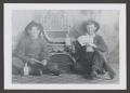 Photograph: [Photograph of two men posing with guns and liquor bottles]