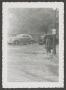 Photograph: [A man and automobiles in a flooded street]