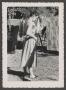 Photograph: [Photograph of Doris Stiles Williams hanging clothes on a clothesline]