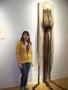 Photograph: [Artist standing next to her woven art]
