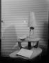 Photograph: [Photograph of a table with a lamp and a binder]