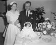 Photograph: [Photograph of a bride and groom cutting their wedding cake]