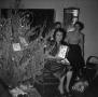 Photograph: [Photograph of three women by a Christmas tree]