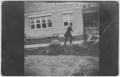 Primary view of [A man walking past a building]