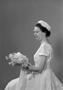 Photograph: [Frieda Warrington in a floral lace dress holding a bouquet]