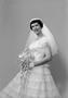 Photograph: [Kathleen Zimmerman in a layered lace dress, holding a bouquet and sm…