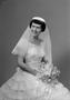 Photograph: [Kathleen Zimmerman in a layered dress smiling and holding a bouquet]