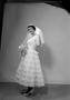 Photograph: [Kathleen Zimmerman standing, wearing a layered dress and veil and ho…