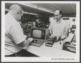 Photograph: [Advertisement featuring a store worker, a customer, and a computer]