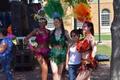 Photograph: [Student standing with three dancers at 2015 Carnaval]