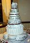 Photograph: [White tiered cake with black and brown detailing]