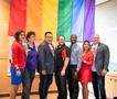 Photograph: [Group in front of Pride flag at LGBTQ exhibit]