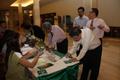 Photograph: [People fill out forms at UNT alumni party in Bangkok, 1]