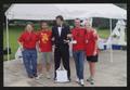 Primary view of [Four individuals in red posed around a mannequin dressed in a black suite: Lone Star Ride 2010 event photo]