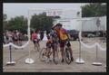 Primary view of [Two cyclists kissing under a fabricated archway: Lone Star Ride 2010 event photo]