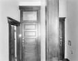 Photograph: [An interior of a building, looking at two doors]