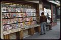 Photograph: [A man browsing a magazine merchant's wares]