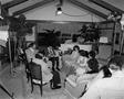 Photograph: [Mike Evans and others sit in living room, 4]