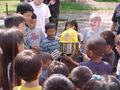 Photograph: [Children surround firefighter at ILD event, closeup]