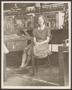 Photograph: [Factory worker seated at her station]
